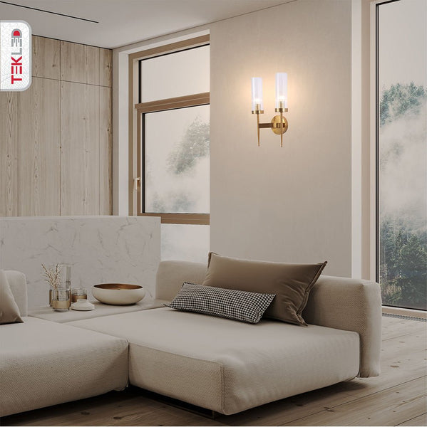 Gold Aluminium Bronze Cylinder Clear Glass Wall Light with 2xE14 Fitting in indoor setting living room